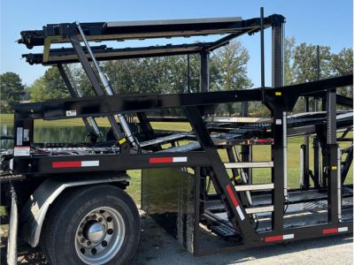 Rows of stacked rectangular and square American-sourced steel tubes and beams stretch into the background of a manufacturing facility, with a person visible in the distance.